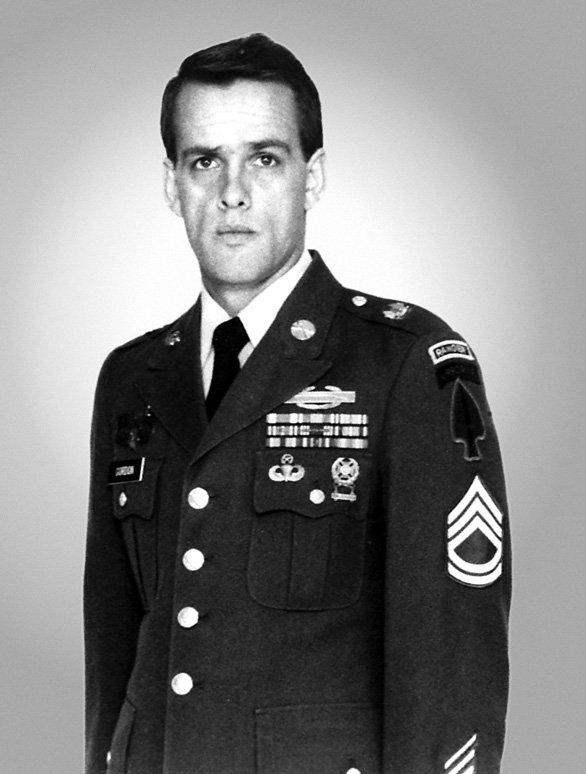 Black and white official Army portrait of Gary Gordon in his green service uniform, with the Ranger tab and Special Forces patch on his left shoulder