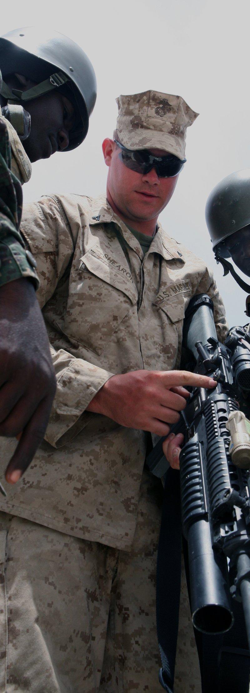A Marine shows soldiers his M16A4 with a grenade launcher