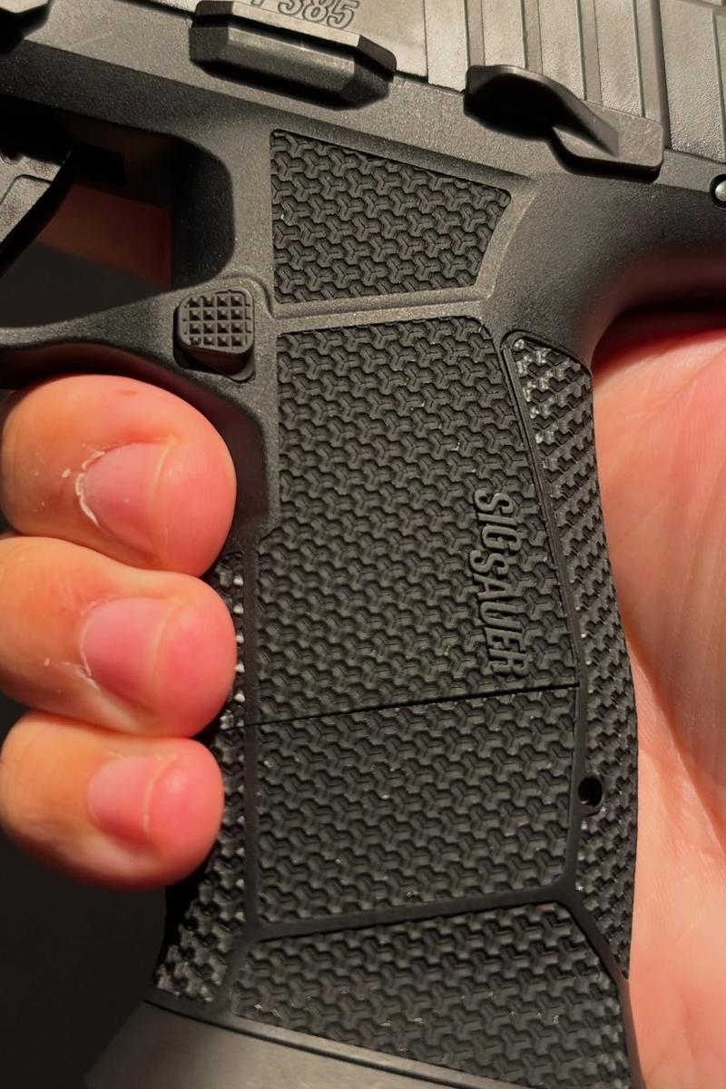 The grip module and flared magwell of a SIG P385, showing the MAGSTRAP texture and where the grip module meets the frame